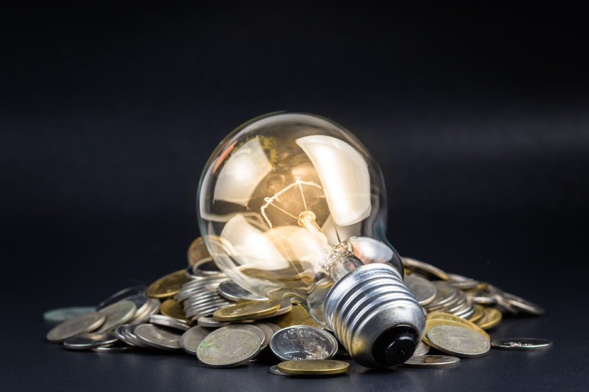 Light bulb and pile of coins, can be used as business idea or energy saving concept